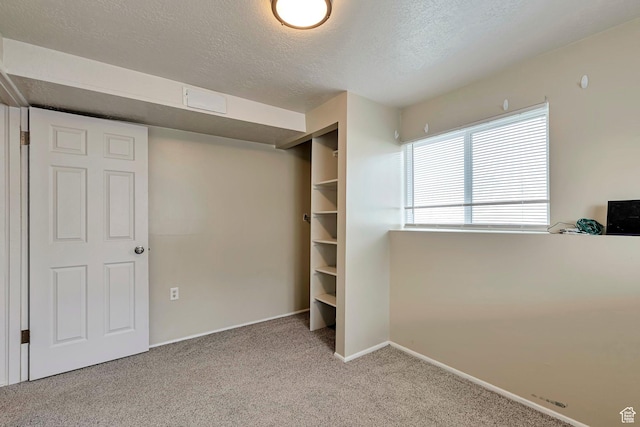 unfurnished bedroom featuring baseboards, carpet, and a textured ceiling