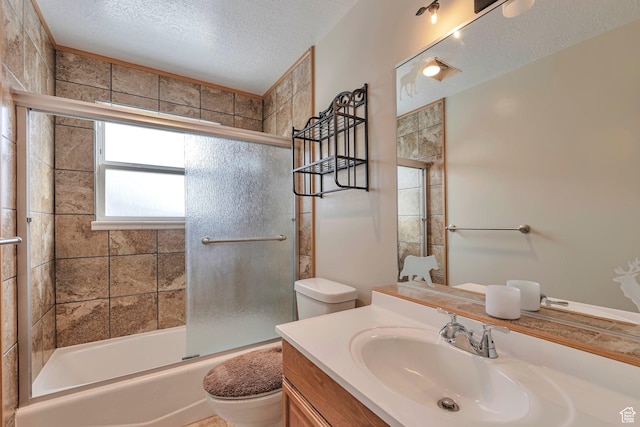 full bath with toilet, vanity, enclosed tub / shower combo, and a textured ceiling