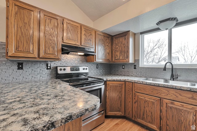 kitchen featuring a sink, brown cabinets, electric stove, and under cabinet range hood