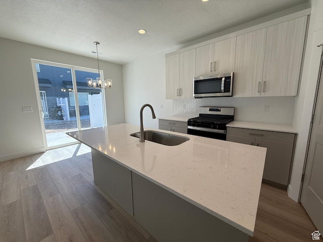 kitchen with appliances with stainless steel finishes, a sink, dark wood finished floors, backsplash, and recessed lighting