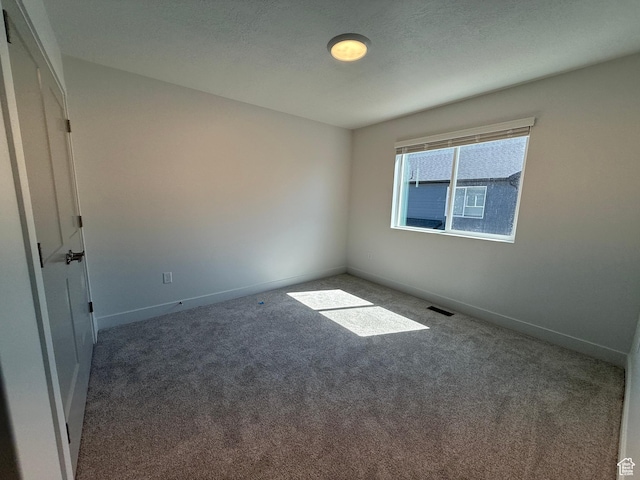 carpeted empty room featuring baseboards