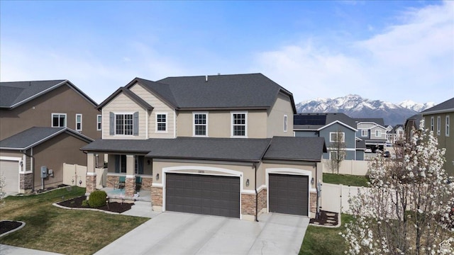 12133 S Broken Arch Ln, Herriman, UT 84096 - view of front of property featuring a garage, stone siding, fence, and concrete driveway