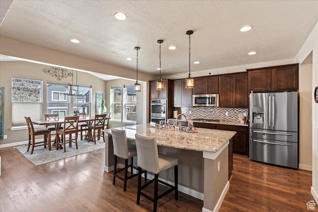 12133 S Broken Arch Ln, Herriman, UT 84096 - kitchen with tasteful backsplash, a textured ceiling, dark brown cabinets, and appliances with stainless steel finishes