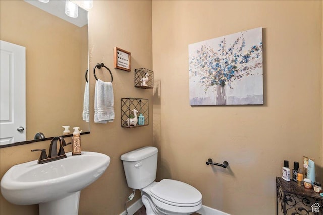 12133 S Broken Arch Ln, Herriman, UT 84096 - half bathroom with toilet, baseboards, and a sink