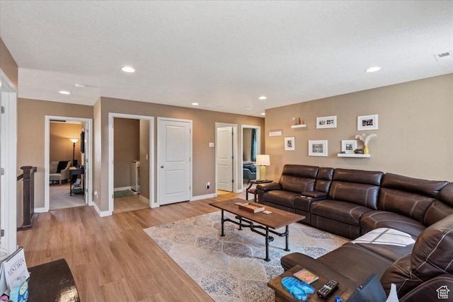12133 S Broken Arch Ln, Herriman, UT 84096 - living room featuring light wood-style floors, baseboards, and recessed lighting
