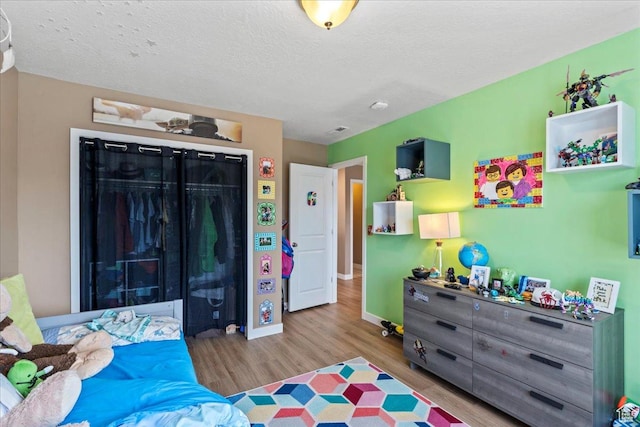 12133 S Broken Arch Ln, Herriman, UT 84096 - bedroom featuring a textured ceiling, a closet, baseboards, and wood finished floors
