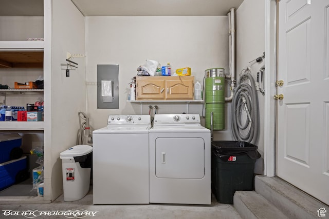 laundry area featuring cabinet space, electric panel, and washer and clothes dryer