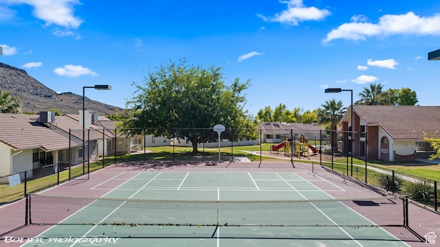 exterior space featuring a mountain view, fence, and playground community