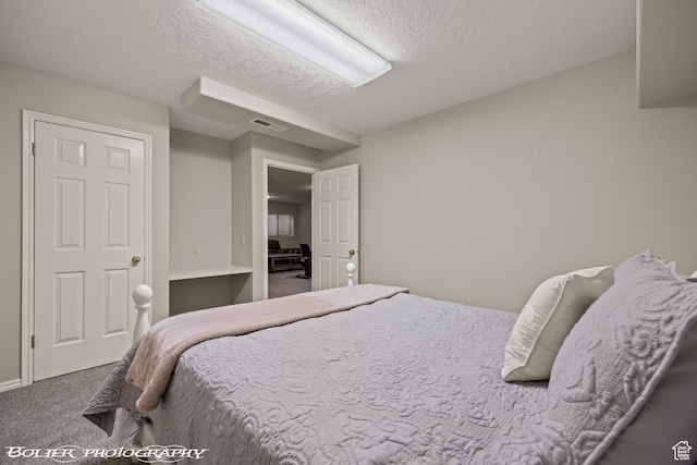 carpeted bedroom with visible vents and a textured ceiling
