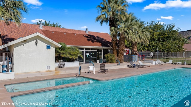 community pool featuring a patio and fence