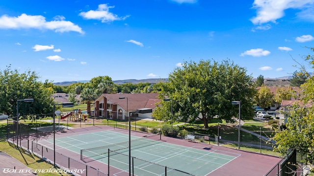 view of sport court featuring fence and a mountain view