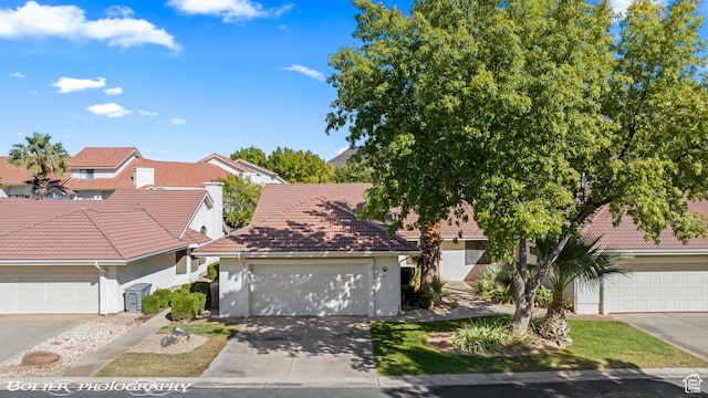 view of front facade featuring a tiled roof, an attached garage, concrete driveway, and stucco siding