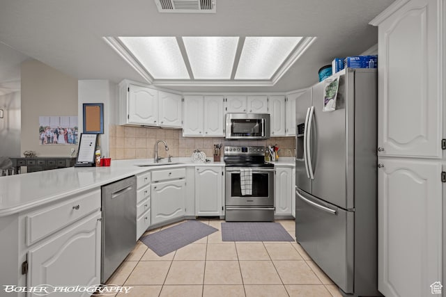 kitchen with decorative backsplash, a sink, visible vents, and stainless steel appliances