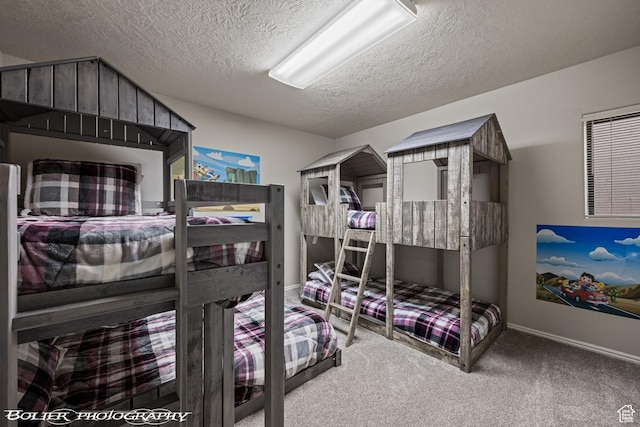 carpeted bedroom featuring a textured ceiling and baseboards