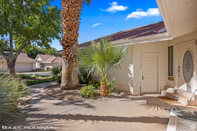 exterior space featuring a tile roof and stucco siding