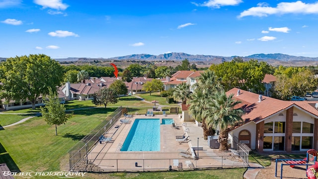 exterior space featuring a lawn, a patio area, fence, a mountain view, and a residential view