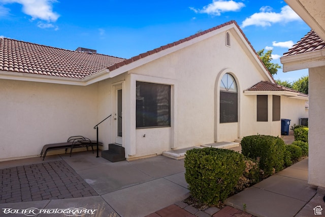 exterior space with a patio, stucco siding, and a tile roof
