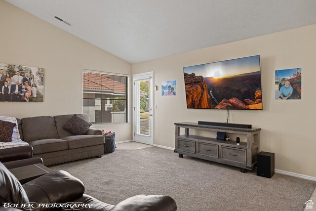 carpeted living area featuring visible vents, baseboards, and vaulted ceiling