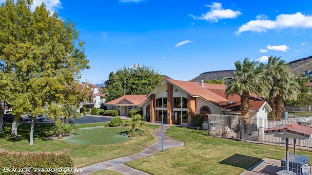 exterior space with stucco siding, fence, and a front lawn