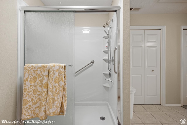 bathroom featuring tile patterned flooring, visible vents, a closet, and a stall shower