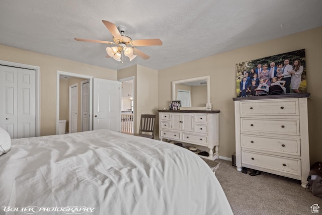 carpeted bedroom featuring baseboards, a ceiling fan, and a textured ceiling