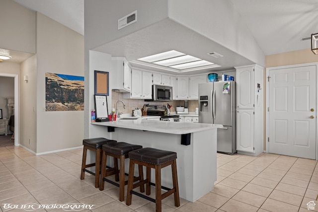 kitchen featuring light tile patterned floors, visible vents, a peninsula, and appliances with stainless steel finishes