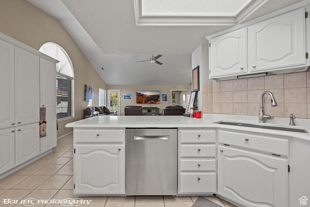 kitchen featuring dishwasher, a sink, open floor plan, a peninsula, and lofted ceiling