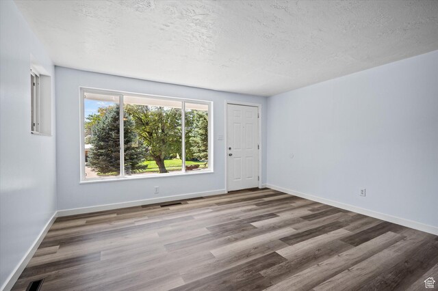 940 Fillmore Ave, Ogden, UT 84404 - spare room with baseboards, visible vents, a textured ceiling, and wood finished floors
