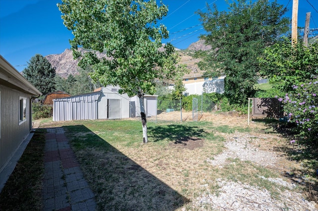 940 Fillmore Ave, Ogden, UT 84404 - view of yard featuring a shed, an outdoor structure, a mountain view, and fence