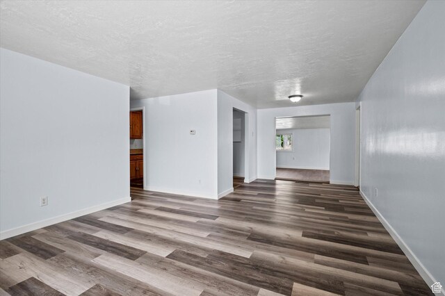 940 Fillmore Ave, Ogden, UT 84404 - unfurnished living room with a textured ceiling, baseboards, and wood finished floors