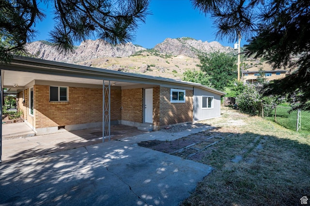 940 Fillmore Ave, Ogden, UT 84404 - rear view of house with a yard, brick siding, a mountain view, and fence
