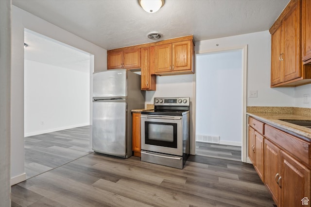 940 Fillmore Ave, Ogden, UT 84404 - kitchen featuring stainless steel appliances, dark wood-style floors, visible vents, and brown cabinets