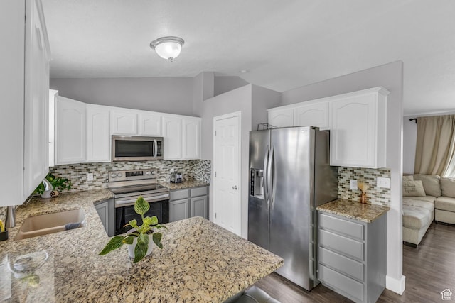 11873 S Coles Camp Cir W, Herriman, UT 84096 - kitchen with tasteful backsplash, white cabinets, vaulted ceiling, light stone countertops, and stainless steel appliances