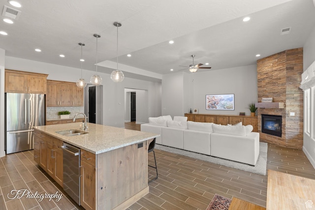 kitchen with open floor plan, visible vents, a sink, and appliances with stainless steel finishes