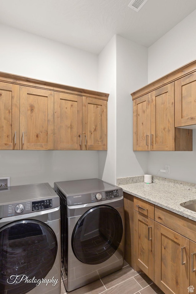 washroom featuring washer and clothes dryer and cabinet space