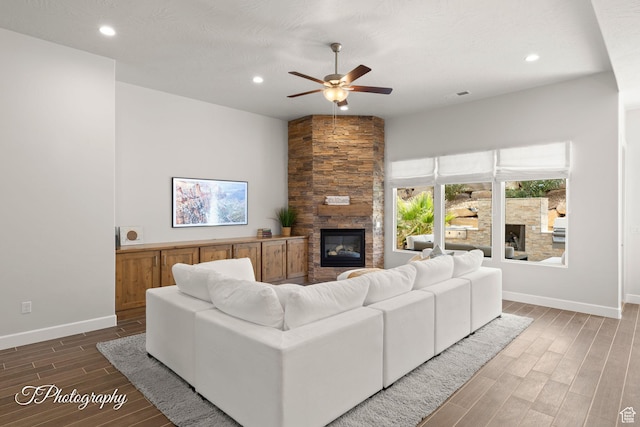 living room with ceiling fan, a fireplace, recessed lighting, wood finished floors, and baseboards