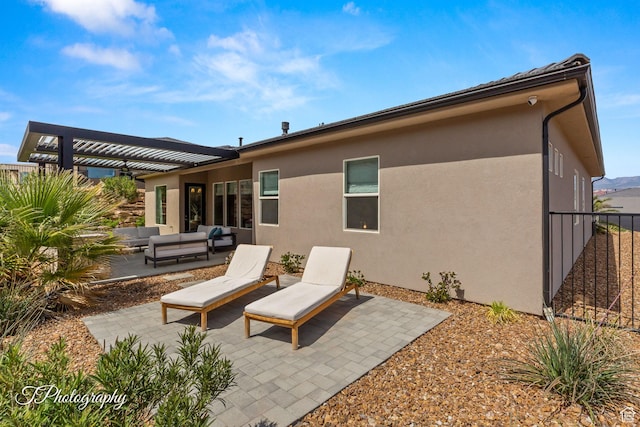 back of house with a pergola, an outdoor hangout area, stucco siding, a patio, and fence