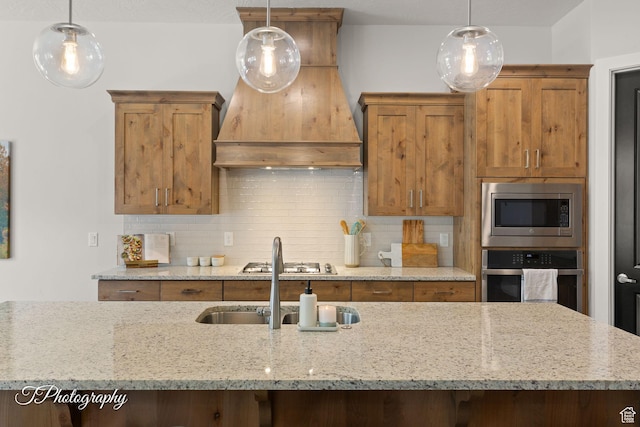 kitchen with custom exhaust hood, decorative backsplash, appliances with stainless steel finishes, and light stone counters