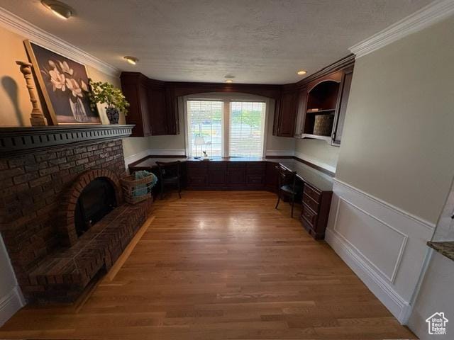 506 S 1200 E, Bountiful, UT 84010 - kitchen with crown molding, dark brown cabinetry, light wood-style floors, wainscoting, and a textured ceiling