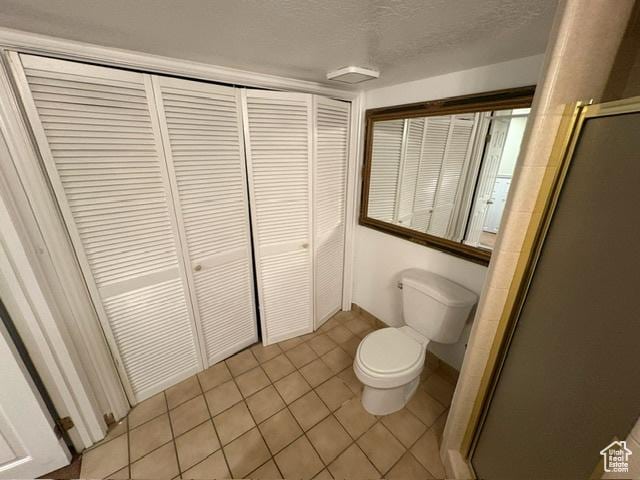 506 S 1200 E, Bountiful, UT 84010 - bathroom featuring toilet, a stall shower, a closet, tile patterned flooring, and a textured ceiling