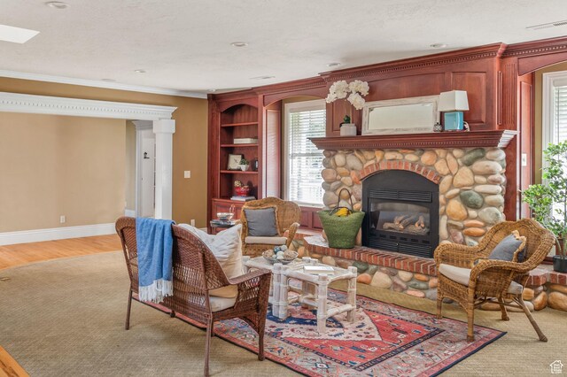 506 S 1200 E, Bountiful, UT 84010 - living room featuring baseboards, a stone fireplace, ornamental molding, visible vents, and light wood finished floors