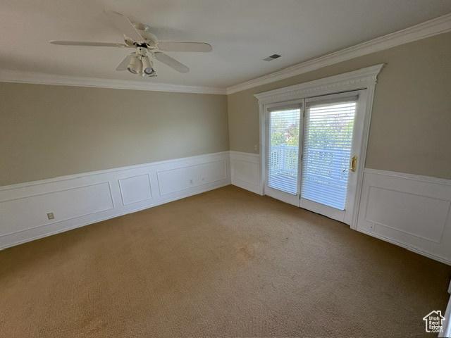 506 S 1200 E, Bountiful, UT 84010 - carpeted empty room with crown molding, a ceiling fan, a wainscoted wall, and a decorative wall