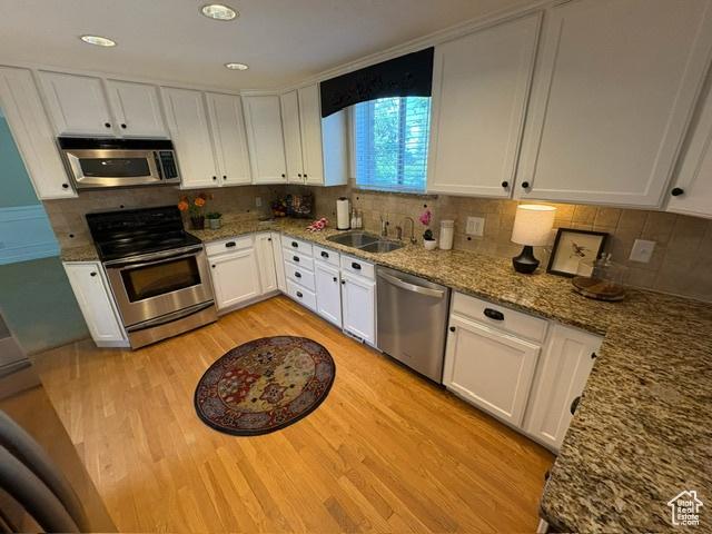 506 S 1200 E, Bountiful, UT 84010 - kitchen featuring stainless steel appliances, light wood-style floors, a sink, white cabinets, and recessed lighting