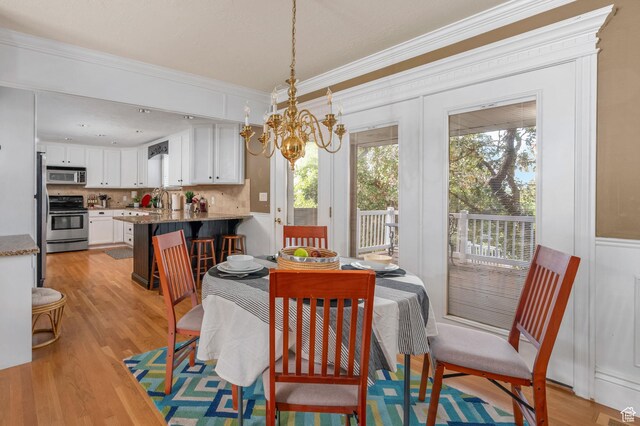 506 S 1200 E, Bountiful, UT 84010 - dining area with light wood-style floors, an inviting chandelier, and ornamental molding