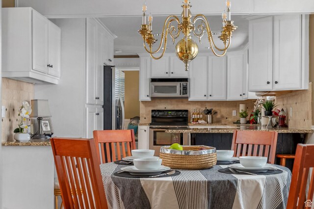 506 S 1200 E, Bountiful, UT 84010 - kitchen featuring a notable chandelier, white cabinetry, backsplash, and appliances with stainless steel finishes