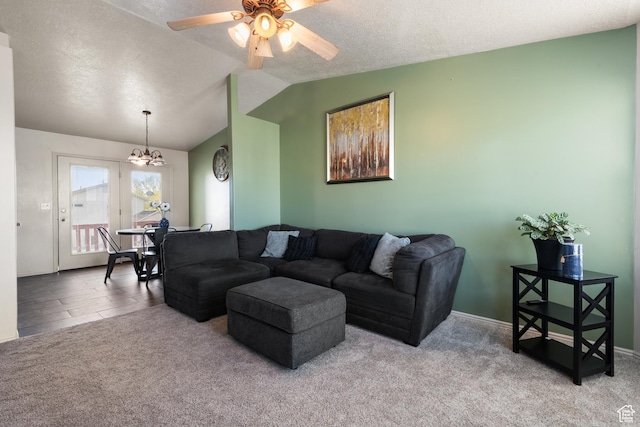 living area with baseboards, a textured ceiling, vaulted ceiling, ceiling fan with notable chandelier, and carpet flooring