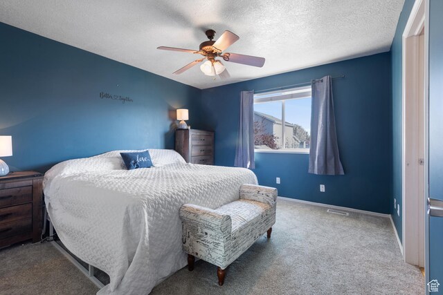 carpeted bedroom featuring a textured ceiling, ceiling fan, baseboards, and visible vents