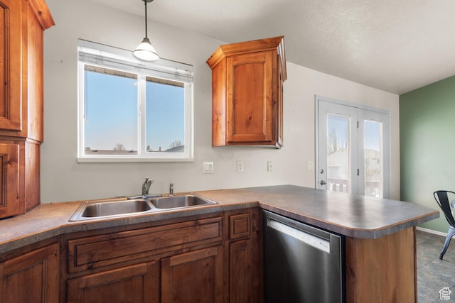 kitchen featuring a sink, a peninsula, brown cabinetry, pendant lighting, and stainless steel dishwasher