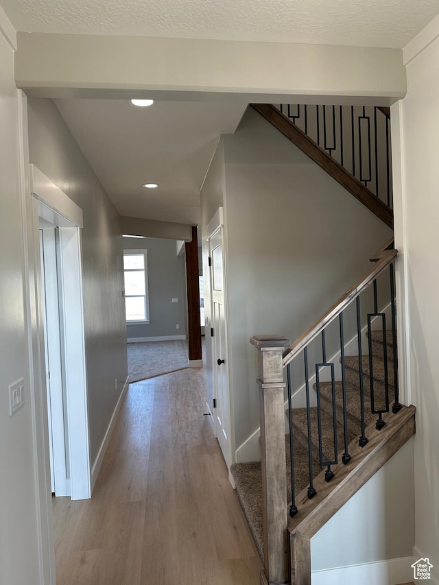hall featuring baseboards, recessed lighting, wood finished floors, and stairs