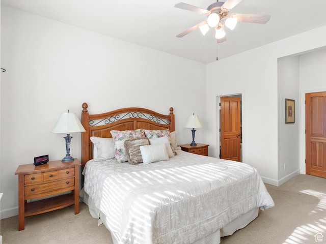 bedroom featuring light colored carpet, baseboards, and ceiling fan